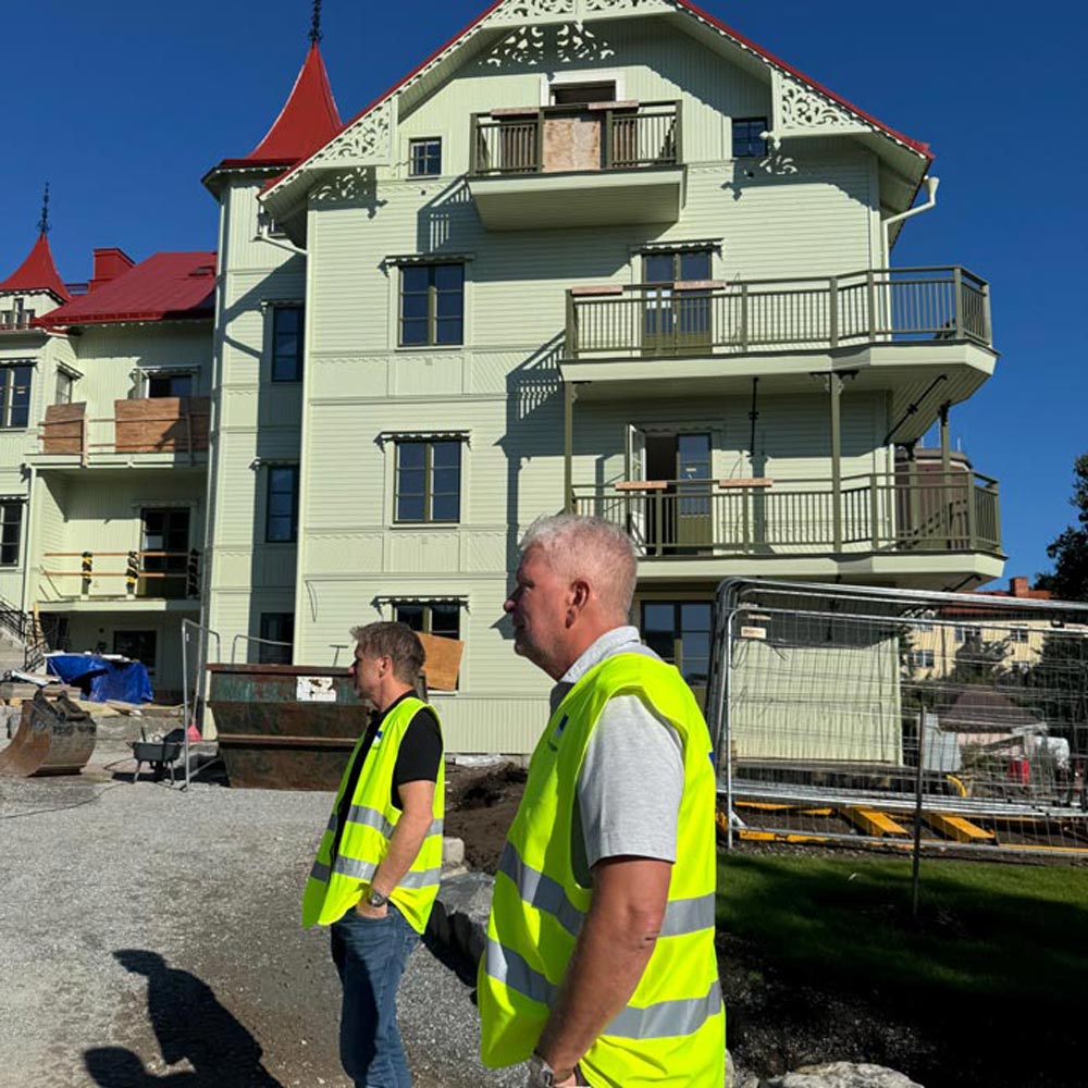 Arbetare står utanför huset undertiden renoveringen pågår