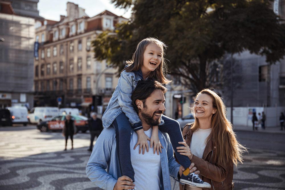 En glad familj som promenerar på stan.